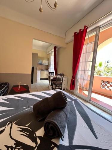 une chambre avec un lit et une grande fenêtre dans l'établissement Studio avec Grand Balcon- Résidence de Caractère, à Bandol
