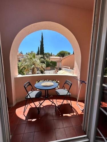 un patio avec une table et des chaises sur un balcon dans l'établissement Studio avec Grand Balcon- Résidence de Caractère, à Bandol