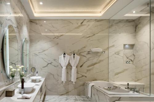 a white bathroom with a tub and a sink and a bath tub at Marchica Lagoon Resort in Nador