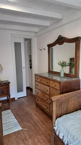 a bedroom with a dresser with a mirror on it at Antonio's home in Colonno