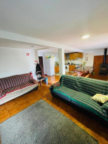 a living room with a couch and a kitchen at O Sitio da Paz in Robalo