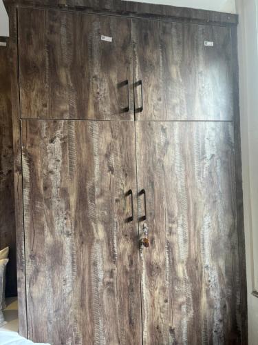 a large wooden cabinet in the corner of a room at Mums Homestay & Studio Apartments in Kathmandu