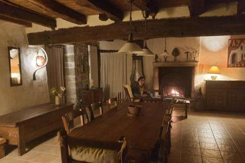 une personne assise à une table dans une pièce avec une cheminée dans l'établissement Charming spacious 150 m old house in Berric, à Berric