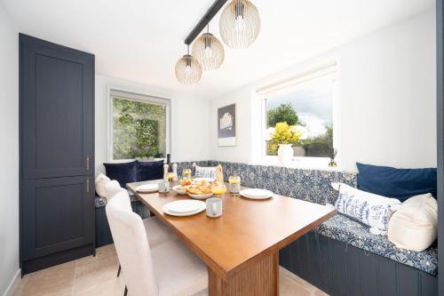 a dining room with a table and a couch at The Garden Cottage with Hot Tub in Portsoy