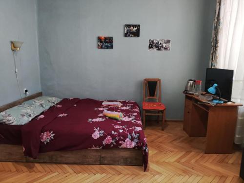 a bedroom with a bed and a desk and a chair at apartment Jessi on Marjanishvili in Tbilisi City