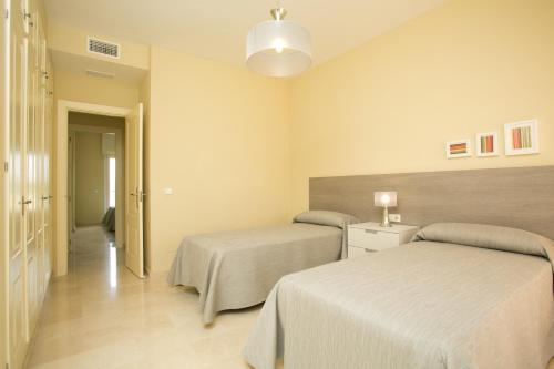 a hotel room with two beds and a hallway at Villas Altos De Marbella in Marbella