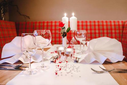 a table with wine glasses and candles on it at Hotel & Restaurant Waldblick in Pulsnitz