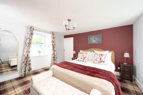 a bedroom with a large bed and a couch at The Garden Cottage with Hot Tub in Portsoy