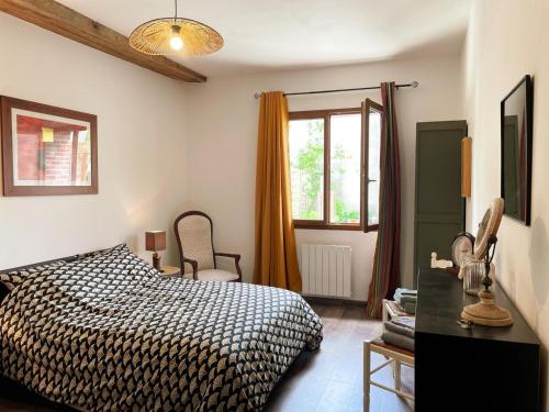 a bedroom with a bed and a desk and a window at Gîte à Oisly près des Châteaux de la Loire avec Parking et Animaux Bienvenus - FR-1-491-469 in Oisly