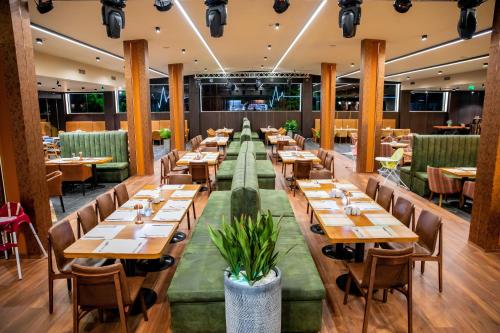 a dining room with wooden tables and chairs at Grand Hotel Bansko - Fitness & SPA in Bansko