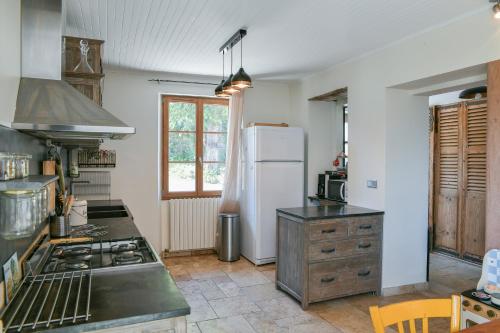 Il comprend une cuisine équipée d'un réfrigérateur blanc et d'une cuisinière. dans l'établissement La Maison Dauphinoise, à Saint-Bueil