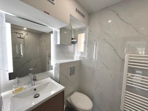 une salle de bain blanche avec un lavabo et des toilettes dans l'établissement Luma - Logement Climatisé Proche Centre & Plages, à Saint-Tropez
