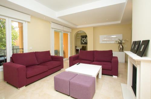 a living room with two purple couches and a table at Villas Altos De Marbella in Marbella