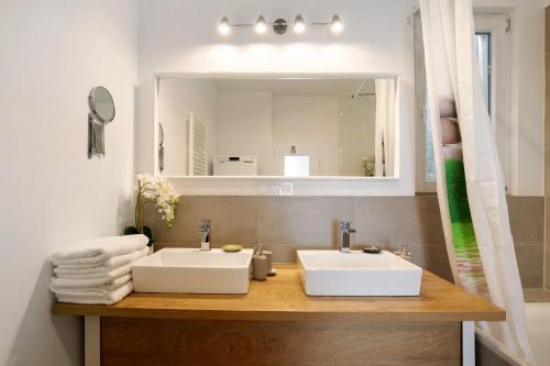 a bathroom with two sinks and a mirror at Apartmenthaus Schlosspark in Worms