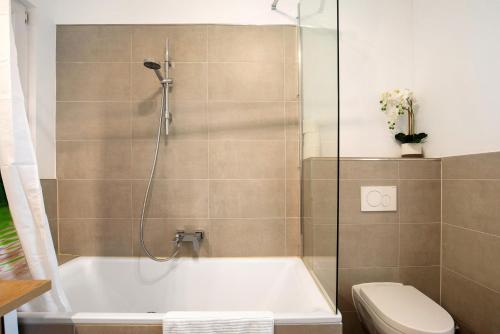 a bathroom with a bath tub and a toilet at Apartmenthaus Schlosspark in Worms