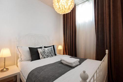 a bedroom with a white bed and a chandelier at Apartmenthaus Schlosspark in Worms