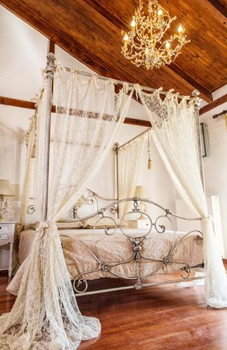 a bedroom with a canopy bed with a chandelier at Luxurious Seafront Villa in Pefkohori in Pefkochori