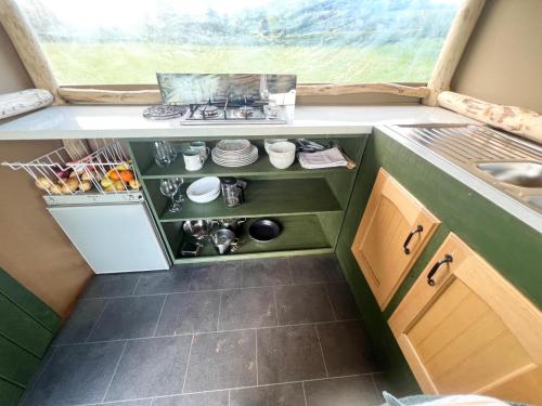a small kitchen with a sink and a stove at Hinton land glampsite in Peterchurch