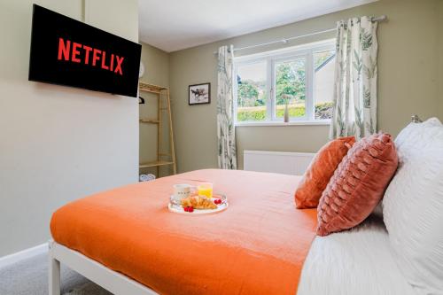 a bed with a plate of food on it at Quiet & Stylish 2-Bed House with Garden & Free Parking in Cwm-brân