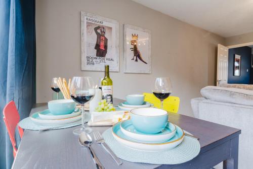 a dining room table with plates and wine glasses at Quiet & Stylish 2-Bed House with Garden & Free Parking in Cwm-brân