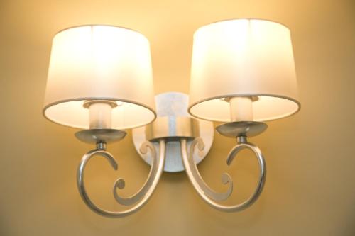 two lights on a wall with white shades at Villas Altos De Marbella in Marbella
