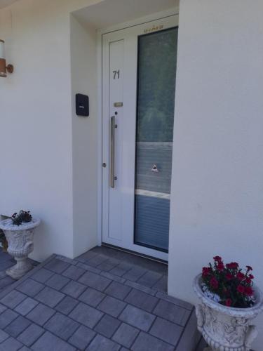 a front door of a house with two vases of flowers at Suite 2 Personen in Wernberg