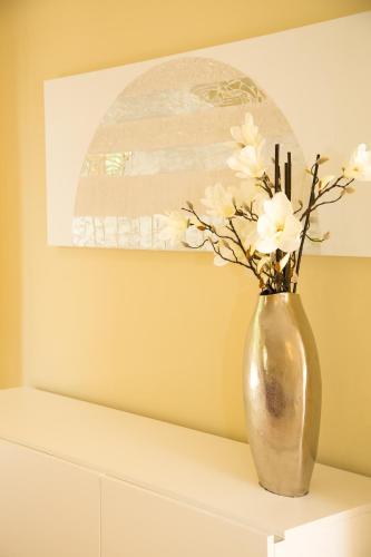 a vase with white flowers sitting on a shelf at Villas Altos De Marbella in Marbella