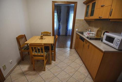 a small kitchen with a table and a microwave at Amore Apartmanhaz in Siófok