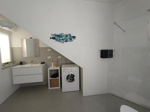 a white kitchen with a sink and a washing machine at Santa Chiara NUOVO Appartamento in centro di Bra in Bra