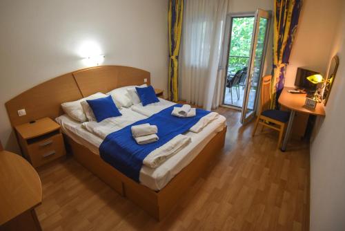a bedroom with a large bed with towels on it at Amore Apartmanhaz in Siófok
