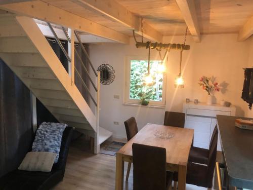 ein Esszimmer mit einem Tisch und einer Treppe in der Unterkunft Luxus Summer Breeze Ferienhaus Lübbesee Sauna Bootssteg Templin in Milmersdorf