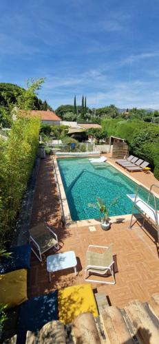 une piscine avec deux chaises longues et une piscine dans l'établissement Maison de vacances les pins clim piscine chauffée, à Six-Fours-les-Plages