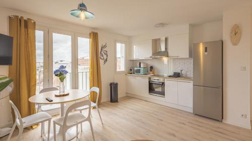 une cuisine et une salle à manger avec une table et un réfrigérateur dans l'établissement Le Refuge 2 - Maréa - Hypercentre - 4 pers, à Troyes