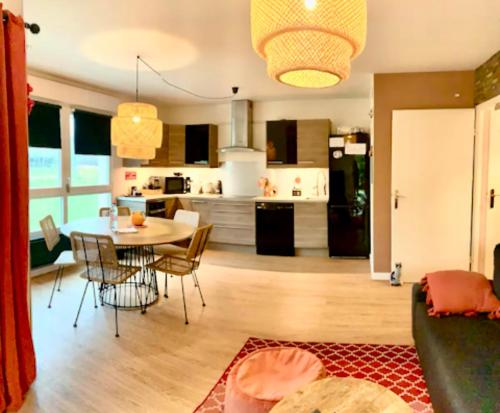 Il comprend un salon et une cuisine avec une table et des chaises. dans l'établissement Appartement 6 personnes jardin parking, à Montévrain