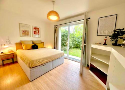une chambre avec un lit et une grande fenêtre dans l'établissement Appartement 6 personnes jardin parking, à Montévrain