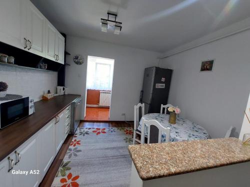 a kitchen with a refrigerator and a table in it at Penty Apartament in Suceava