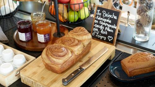 a table with a cutting board with bread and a knife at Campanile NATURE - Marne La Vallée - Chelles in Chelles