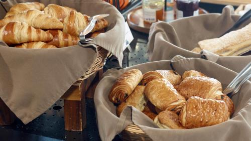 two baskets filled with different types of bread on a table at Campanile NATURE - Marne La Vallée - Chelles in Chelles