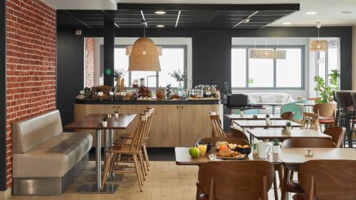 un restaurant avec des tables et des chaises et un bar dans l'établissement Campanile NATURE - Marne La Vallee Chelles - Villepinte, à Chelles