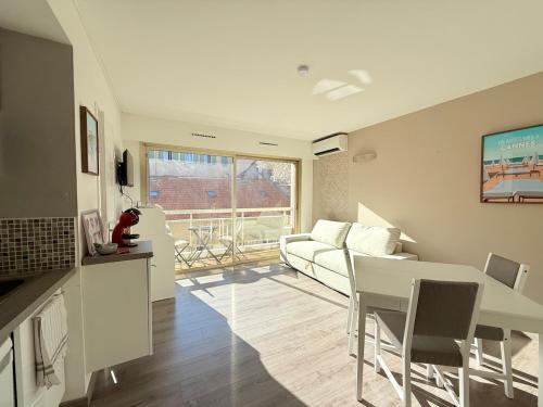 un salon avec une table blanche et un canapé dans l'établissement 25m2 - Coeur De Ville, Vue mer, à Cannes