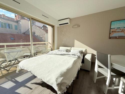 une chambre avec un lit et un balcon avec une table dans l'établissement 25m2 - Coeur De Ville, Vue mer, à Cannes