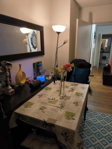 un salon avec une table avec un vase de fleurs dessus dans l'établissement Appartement agréable, à Saint-Denis