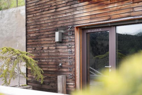 a wooden building with a door with numbers on it at Ansitz Röfen in Burgusio