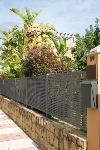 a fence with flowers on top of a wall at Villas Altos De Marbella in Marbella