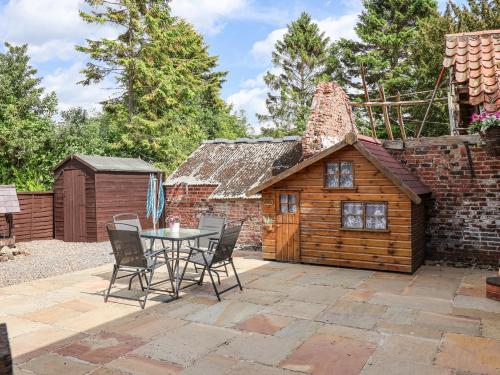 a patio with a table and a small cabin at Croft Granary in Stillington
