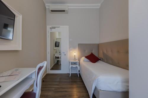 a bedroom with a bed and a desk and a television at Hotel Degli Oleandri in Sirmione
