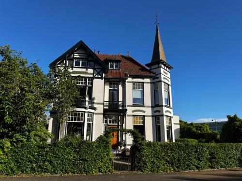 a large white house with a spire on top of it at B&B Villa Frisia in Steenwijk