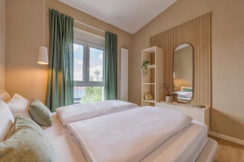 a bedroom with two beds and a mirror and a window at Adler Apartments in Ettenheim