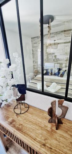 une table avec un oiseau bleu assis au-dessus dans l'établissement N3-Barbacane-Pieds Cité-Clim mobile, à Carcassonne