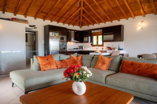 una sala de estar con sofá y un jarrón de flores sobre una mesa en Runway Mansion, stunning views and lots of space, en Skiathos